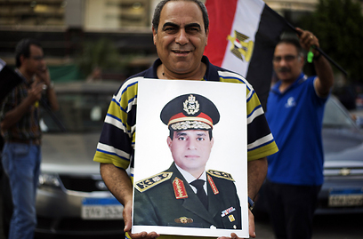 אזרח מצרי מניף את כרזת הגנרל סיסי, מפקד הכוחות המזוינים (צילום: AFP) (צילום: AFP)