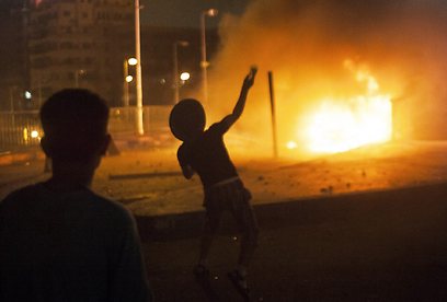 מתנגדי מורסי מבעירים אש בקהיר (צילום: AP) (צילום: AP)