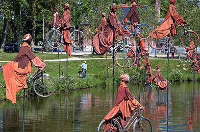 אמנות על גלגלים. מיצג של האמן הצרפתי גי לורג'רה נקרא "שיבה לבטון", פרבר בעיר ראן, והוא מסמל את האנשים שמהגרים באופניים מגדה אחת של הנהר לגדה השנייה (צילום: AFP) (צילום: AFP)