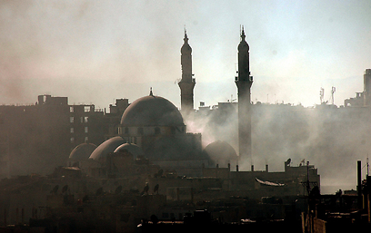 משטר אסד ממקד את הלחימה בערים הגדולות. עשן באזור מסגד בן אל-וואליד בחומס (צילום: EPA) (צילום: EPA)