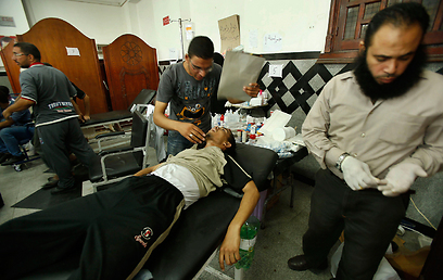 מטפלים באחד הפצועים. גם לצבא יש נפגעים (צילום: רויטרס) (צילום: רויטרס)