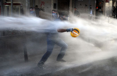 מפגין בפני זרנוק מים  (צילום: AFP) (צילום: AFP)