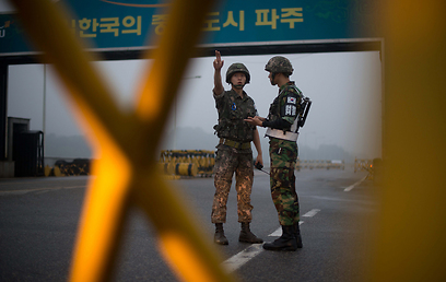 חיילים דרום קוריאנים עומדים במעבר הגבול עם צפון קוריאה שמוביל לאזור התעשייה המשותף לשתי המדינות קיסונג (צילום: AFP) (צילום: AFP)