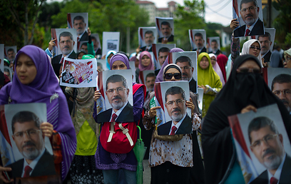 מפגינים איסלאמים בהפגנת תמיכה בנשיא מצרים המודח מוחמד מורסי מחוץ לשגרירות המצרית בקואלה לומפור, בירת מלזיה (צילום: AFP) (צילום: AFP)