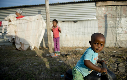 ילד דרום אפריקני משחק בסמוך למכרה הפלטינה "לונמין" שבו נהרגו בשנה שעברה 36 בני אדם בעימותים בין שוטרים לבין עובדים שהתבצרו במכרה (צילום: AFP) (צילום: AFP)