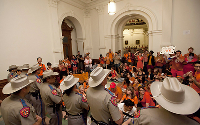 פעילים נגד החוק, לבושים בכתום, ברגע ההחלטה בטקסס (צילום: AP) (צילום: AP)