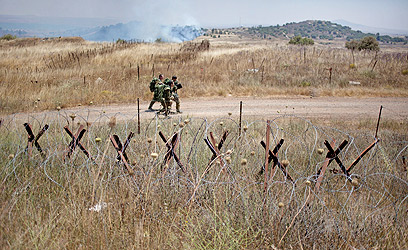 חיילים בגבול, ברקע נפילות (צילום: AP) (צילום: AP)