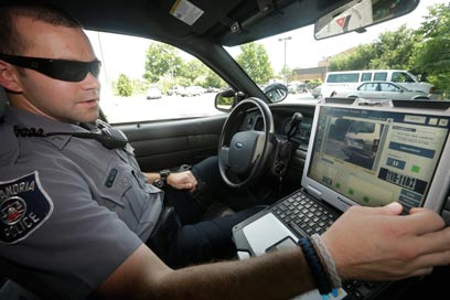 שוטר בווירג'יניה משתמש במחשב שבניידת כדי לסרוק לוחיות רישוי (צילום: AP) (צילום: AP)