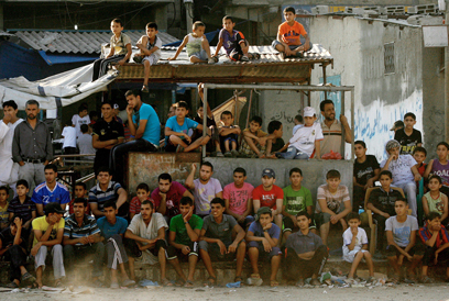 בזמן שהם ממתינים לשלום שיפרוץ באזור צופים צעירים פלסטינים במשחק כדורגל במחנה הפליטים ברפיח (צילום: AFP) (צילום: AFP)