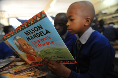 תלמיד בית ספר בקניה קורא את הספר "נלסון מנדלה - דרך ארוכה לחירות" ביום שבו ציינו את יום הולדתו ה-95 של נשיא דרום אפריקה לשעבר וחתן פרס נובל לשלום שמאושפז בבית חולים במצב קשה (צילום: AFP) (צילום: AFP)