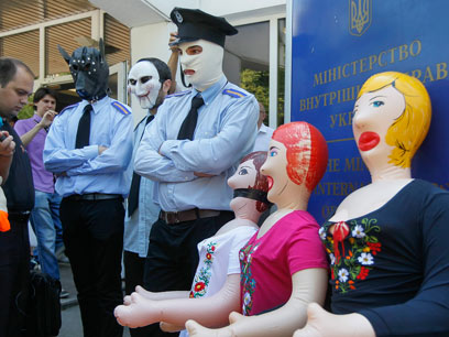 מפגיני אופוזיציה מחופשים לשוטרים עם בובות נשים, מפגינים למען אירינה (צילום: EPA) (צילום: EPA)