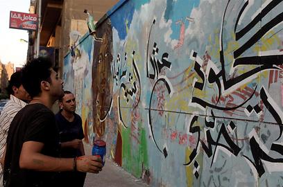 אמן הגרפיטי עמאר אבו באקר בקהיר. "לא הזמן למחאה" (צילום: רויטרס) (צילום: רויטרס)
