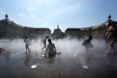 מזרקות המים בעיר הצרפתית בורדו הפכו למקום מפלט לאנשים רבים שביקשו לצנן את גופם בימי הקיץ הלוהטים (צילום: AFP) (צילום: AFP)