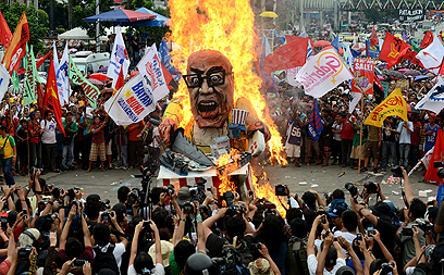 מפגינים במנילה שרפו בובה בדמותו של נשיא הפיליפינים בנינו אקינו בטרם נאומו בפרלמנט על מצב האומה (צילום: AFP) (צילום: AFP)