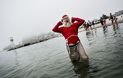 אדם מחופש לסנטה קלאוס טובל במי הים צפונית לעיר קופנהגן בטקס שמסמן את פתיחת קונגרס סנטה קלאוס השנתי בדנמרק (צילום: AFP) (צילום: AFP)