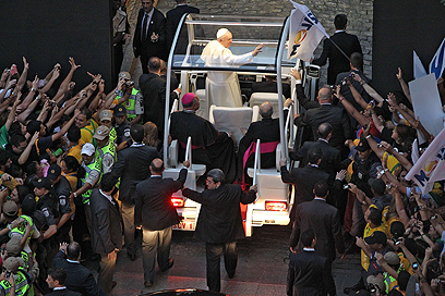 האפיפיור פרנסיסקוס מנופף לקהל המאמינים מרכב הפופמוביל שלו במהלך ביקורו בריו דה ז'ניירו (צילום: AFP) (צילום: AFP)