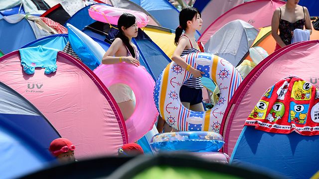צעירות יפניות בדרך לבריכה בטוקיו (צילום: AFP) (צילום: AFP)