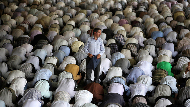 עומד בדד, בים של מתפללים. תפילת רמדאן באוניברסיטת טהרן (צילום: AP) (צילום: AP)