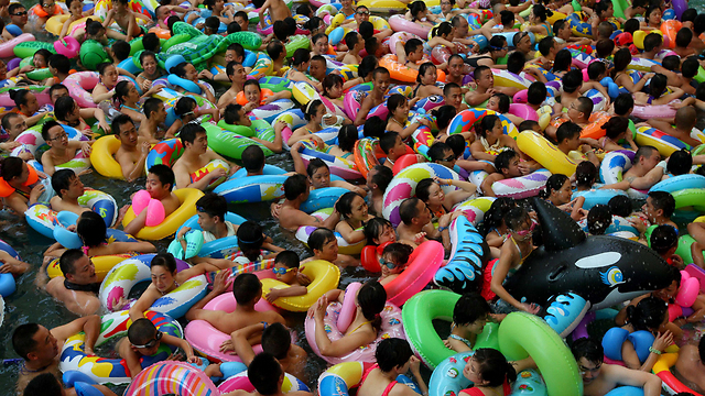 תושבי מחוז סצ'ואן בסין מנסים להפיג את החום בפארק המים סווינינג (צילום: AFP) (צילום: AFP)