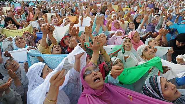 נשים מוסלמיות בקשמיר ההודית מתפללות בפני שריד ארכיאולוגי שעל פי אמונתן הוא חתיכת שיער מזקנו של הנביא מוחמד (צילום: AFP) (צילום: AFP)