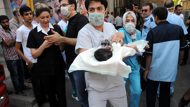 צוות רפואי מפנה תינוק מתוך בית חולים שבו פרצה שריפה בעיר דיארבקיר שבדרום-מזרח טורקיה (צילום: AFP) (צילום: AFP)