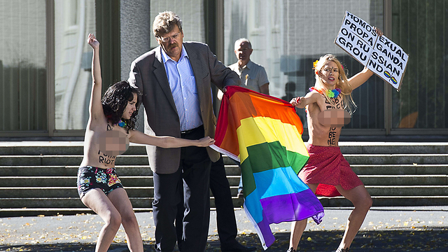 במהלך שבוע הגאווה בשטוקהולם פרצו שתי פעילות בארגון הפמיניסטי "פמן" לשגרירות רוסיה בבירה השבדית ואחזו בדגל הגאווה ובשלט שעליו נכתב: "תעמולה הומוסקסואלית על אדמה רוסית". (צילום: AFP) (צילום: AFP)
