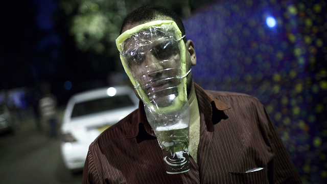 תומך של נשיא מצרים המודח מוחמד מורסי חובש מסיכת גז ביתית כדי להגן על עצמו במהלך הפגנה שנערכה ליד אוניברסיטת קהיר בעיר גיזה (צילום: AP) (צילום: AP)