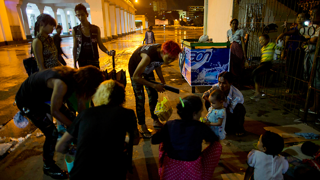 קייוו קייוו וחבריו מחלקים מזון לנזקקים בעיר יאנגון (צילום: AP) (צילום: AP)
