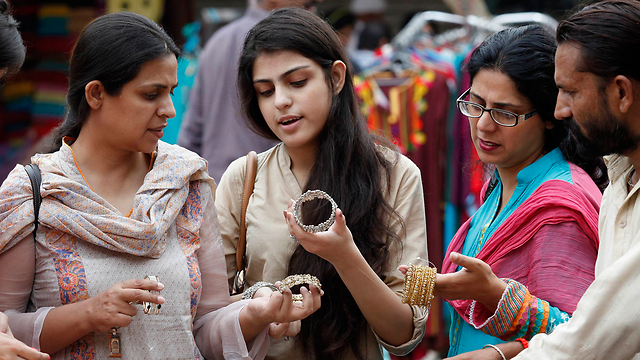 Women shop for bracelets in Pakistan holiday market (Photo: Reuers)