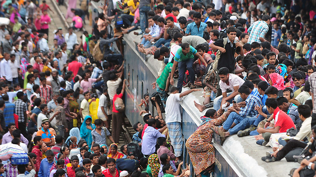 בנגלדש: נוסעים מנסים להידחף אל תוך רכבת בדאקה, בניסיון לחזור למשפחותיהם בכפרים שמחוץ לבירה לקראת החג המוסלמי עיד אל פיטר (צילום: AFP) (צילום: AFP)