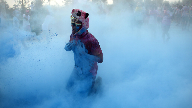 משתתף ב"מרוץ הצבעים" בבייג'ינג מותקף באבקת צבע כחול. כמה אלפי אנשים השתתפו במרוץ, במסגרתו הם מותקפים באבקות צבעוניות לאורך מסלול של 5 ק"מ (צילום: AFP) (צילום: AFP)