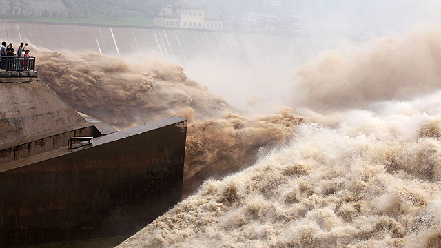 תיירים משקיפים על המים בנהר הצהוב במחוז הנאן בסין, מים שהמונח "שוצפים" קטן עליהם (צילום: AFP) (צילום: AFP)