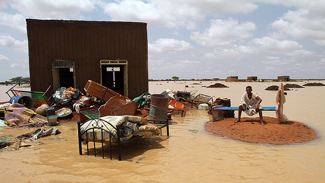 השיטפונות הגיעו גם לסודן שבאפריקה. האיש הזה יושב ליד ביתו באזור חרטום שנהרס (צילום: AFP) (צילום: AFP)