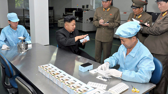 השליט קים ג'ונג און בודק "סלולרי מתוצרת עצמית" (צילום: AFP) (צילום: AFP)