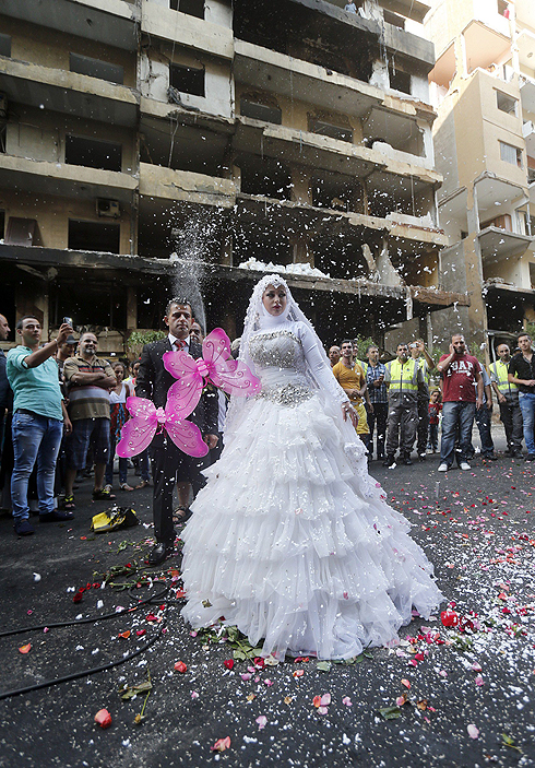 בני הזוג באתר הפיגוע. "החיים ממשיכים בתוך החורבן" (צילום: AFP) (צילום: AFP)