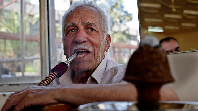 אזרח סורי מעשן נרגילה בבירה הסורית. "מי שהפגין בעבר שינה את דעתו" (צילום: AP) (צילום: AP)