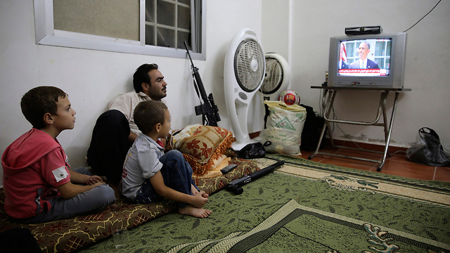 "משחקים בנו כמו בבובות". משפחה תומכת אופוזיציה צופה בנאום (צילום: רויטרס) (צילום: רויטרס)