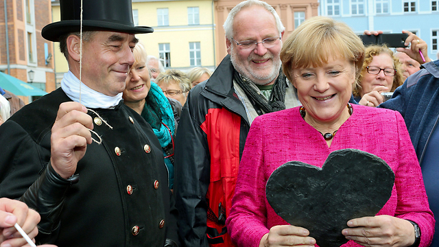 התמודדות טובה למדי עם המשבר הכלכלי. מרקל זוכה לאהבה בברלין (צילום: EPA) (צילום: EPA)