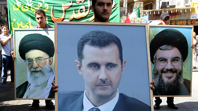 Pro-Syrian protesters carry posters of Assad, Nasrallah and Iran's Ayatollah Khamenei (Photo: Reuters) 