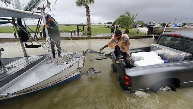 דייגים מושכים סירותם מהמים לקראת הסופה (צילום: AP) (צילום: AP)