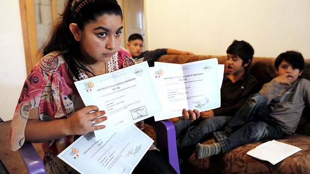 לאונרדה מחזיקה בתעודות מבית הספר בצרפת (צילום: AFP) (צילום: AFP)