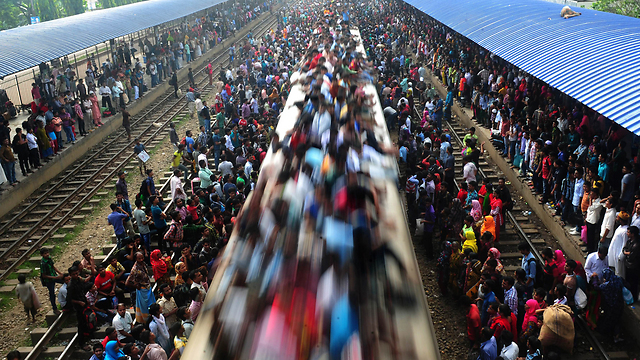 רכבת עמוסה בנוסעים יוצאת לדרכה מבירת בנגלדש דאקה לפרבריה (צילום: AFP) (צילום: AFP)