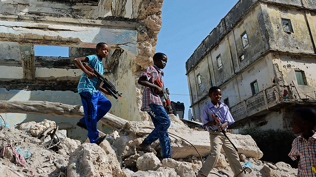 ילדים בבירת סומליה מוגדישו משחקים ברובים במהלך חגיגות חג הקורבן (צילום: AFP) (צילום: AFP)