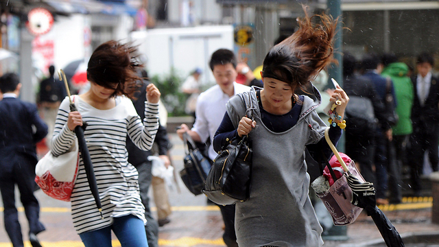 תושבי העיר טוקיו נאבקים בגשם והרוח החזקים שהביאה עמה סופת הציקלון "פיילין" (צילום: AFP) (צילום: AFP)