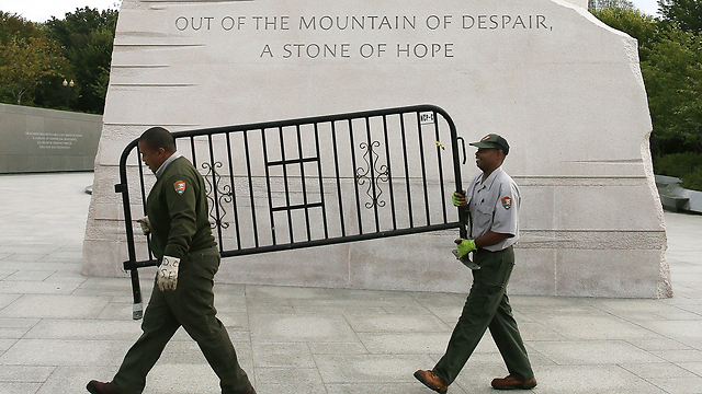 עובדים פדרלים מפנים מחסומים באזור אנדרטת מרטין לותר קינג בוושינגטון. העובדים שבו לעבודה לאחר שהנשיא ברק אובמה חתם על חוק התקציב שהביא לסיום את השבתת הממשל (צילום: AFP) (צילום: AFP)