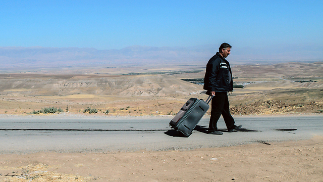 פליט סורי סוחב את מזוודתו אחרי שהוא ופליטים נוספים לא קיבלו אישור כניסה לשטח עיראק (צילום: AFP) (צילום: AFP)