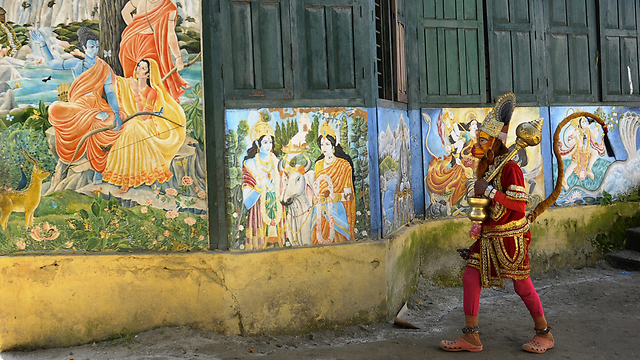 נזיר לבוש בבגדי הנומאן, אחד האלים בהינדואיזם, צועד ברחוב בקטמנדו. הנומאן מתואר כקוף בעל גוף אדם ומסמל עוצמה ונאמנות (צילום: AFP) (צילום: AFP)