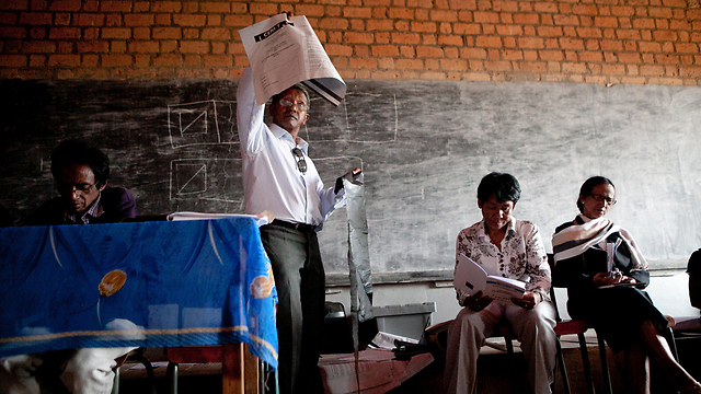 חברי ועדת הבחירות במדגסקר מציבים עמדת הצבעה בבירה אנטננריבו לקראת הבחירות לנשיאות  (צילום: AFP) (צילום: AFP)