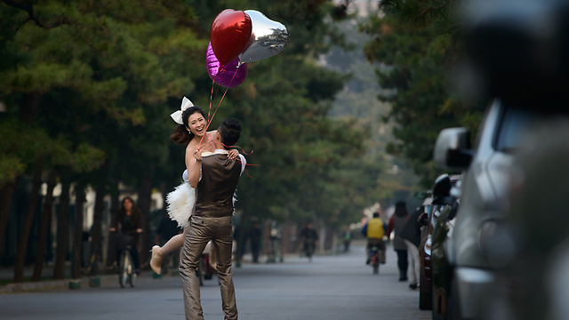 חתן וכלה מצטלמים בבייג'ינג ביום חתונתם (צילום: AFP) (צילום: AFP)
