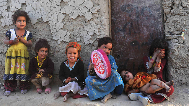 ילדים אפגנים שנעקרו מבתיהם יושבים מחוץ לבית ארעי בפרברי קאבול (צילום: AFP) (צילום: AFP)